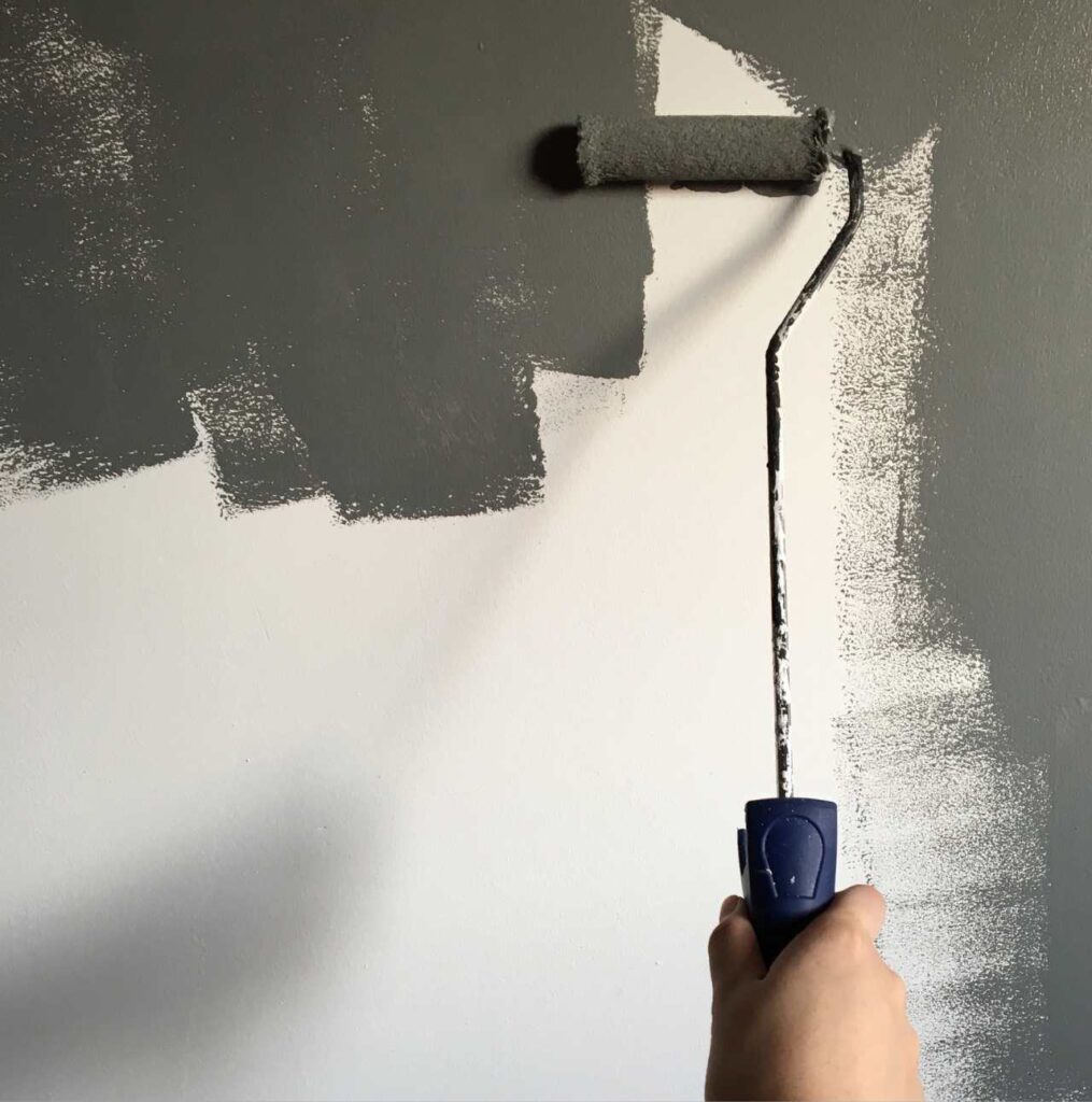 Mano con rodillo pintando pared