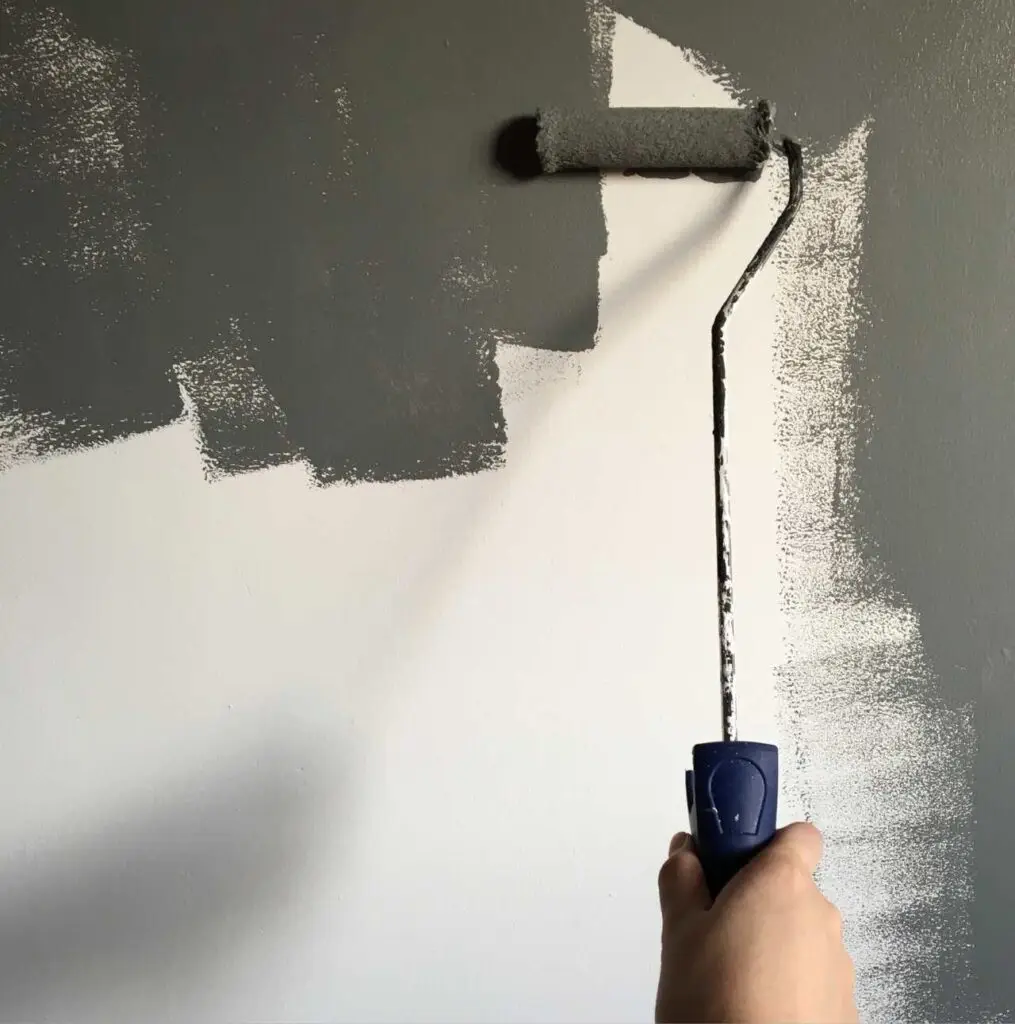 Mano con rodillo pintando pared